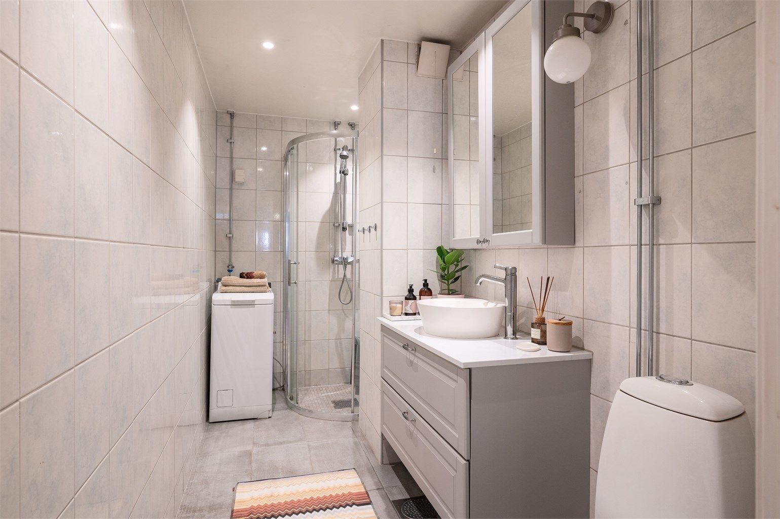 Flislagt bad med elektrisk gulvvarme og opplegg for vaskemaskin.