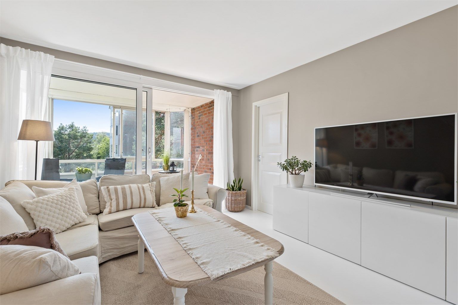 Fra stuen er det utgang til boligens innglassede balkong.