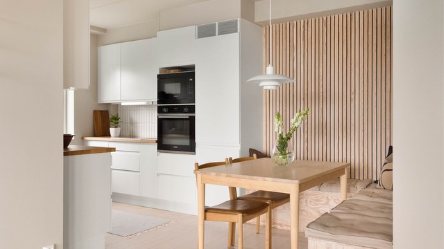 Spiseplassen er smart plassert i tilknytning til kjøkkenet, med en dekorativ spilevegg som skaper en lun og innbydende atmosfære.