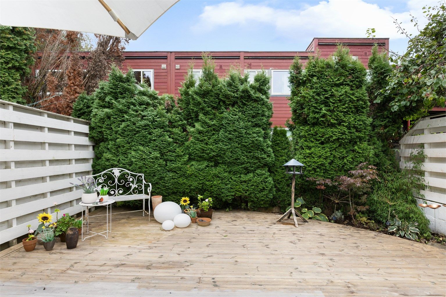 Stor og usjenert uteplass, med platting og blomsterbed