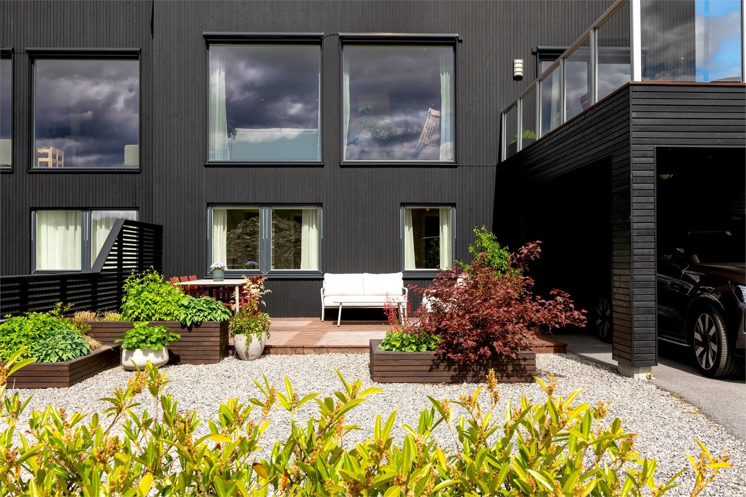 Tomten er opparbeidet med plen, singel og beplantning.