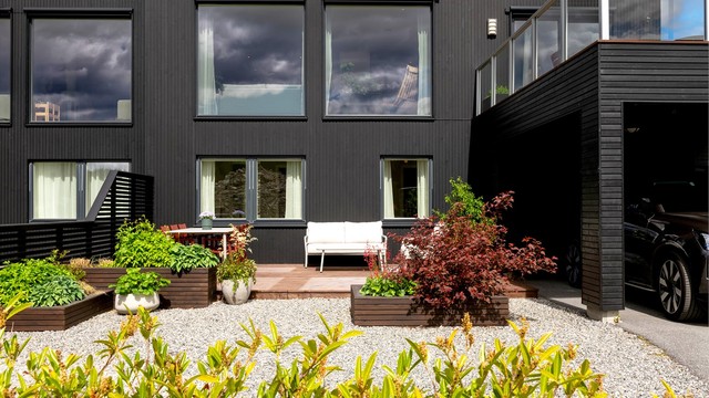 Tomten er opparbeidet med plen, singel og beplantning.