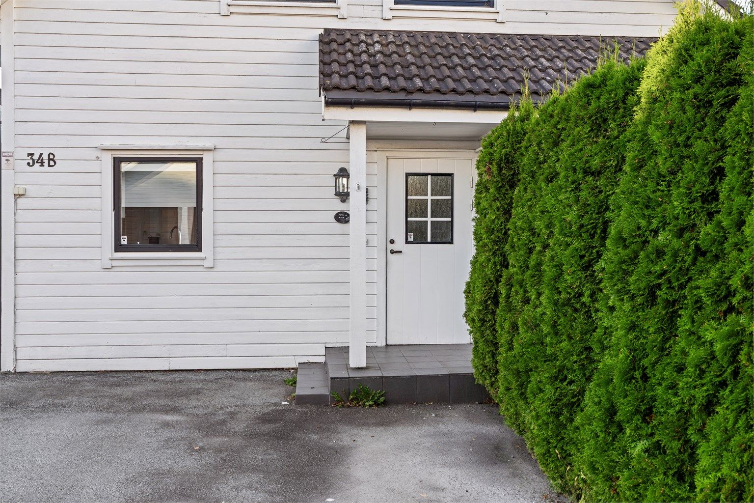 Overbygget inngangsparti med flislagt trapp ved inngangsdøren.