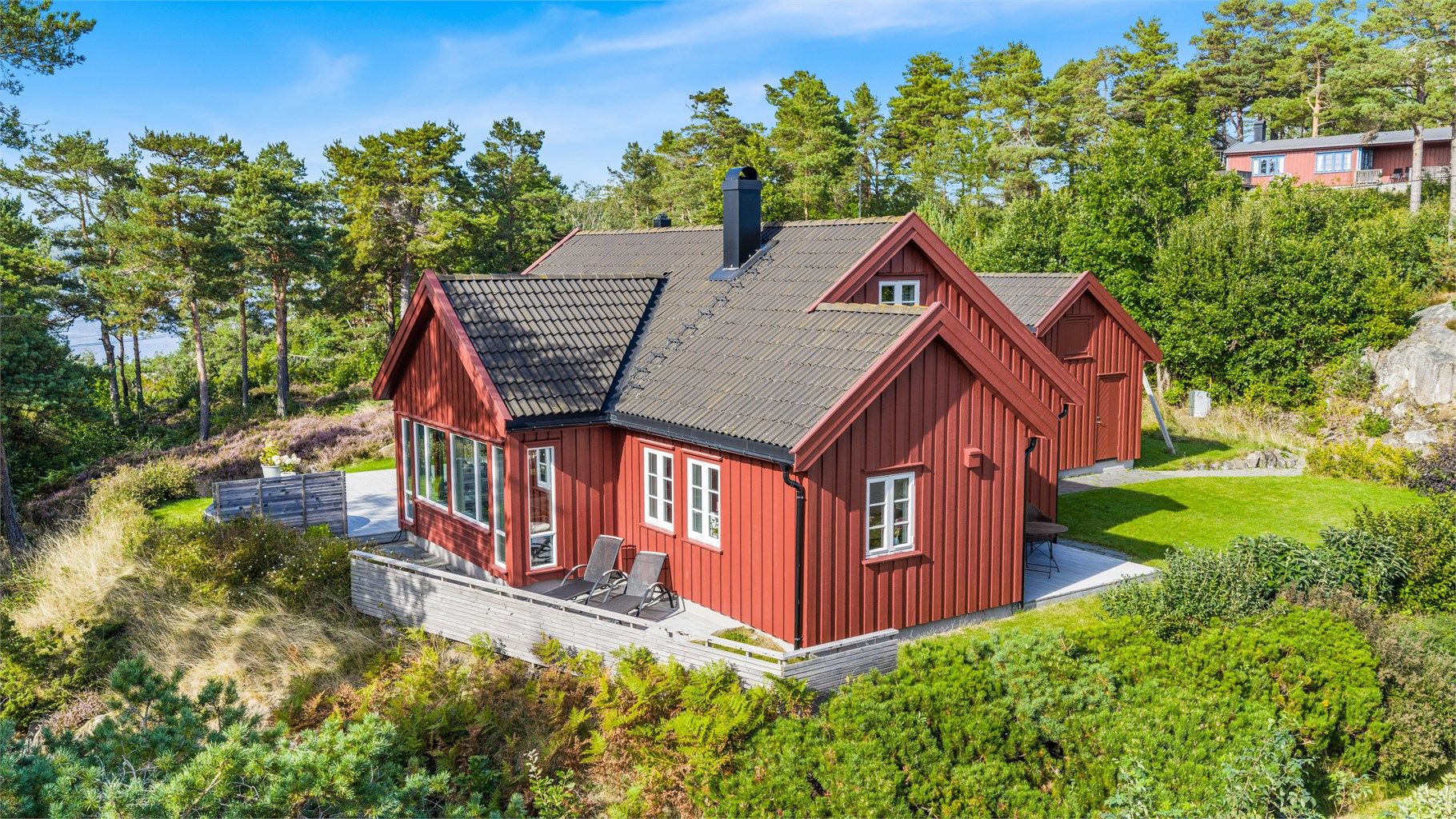 Usjenert og sjønær eiendom på Tromøy med fritidsbolig og anneks, omkranset av stor terrasse og naturskjønne omgivelser. 