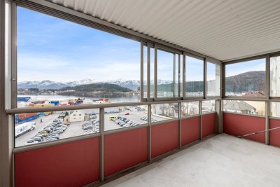 Innglasset balkong på med flotte utsiktsforhold mot fjord og fjell