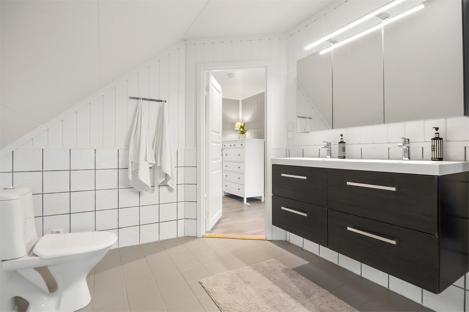 Baderomsinnredningen har en dobbel, ovenpåliggende servant som ble montert i 2024. Toalettet er fra 2022.