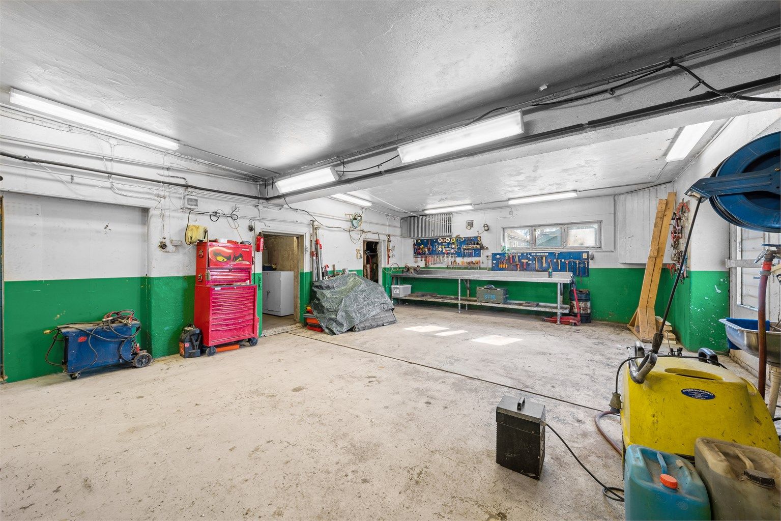 Stor garasje i kjeller med fire porter og godt med bodplass. 