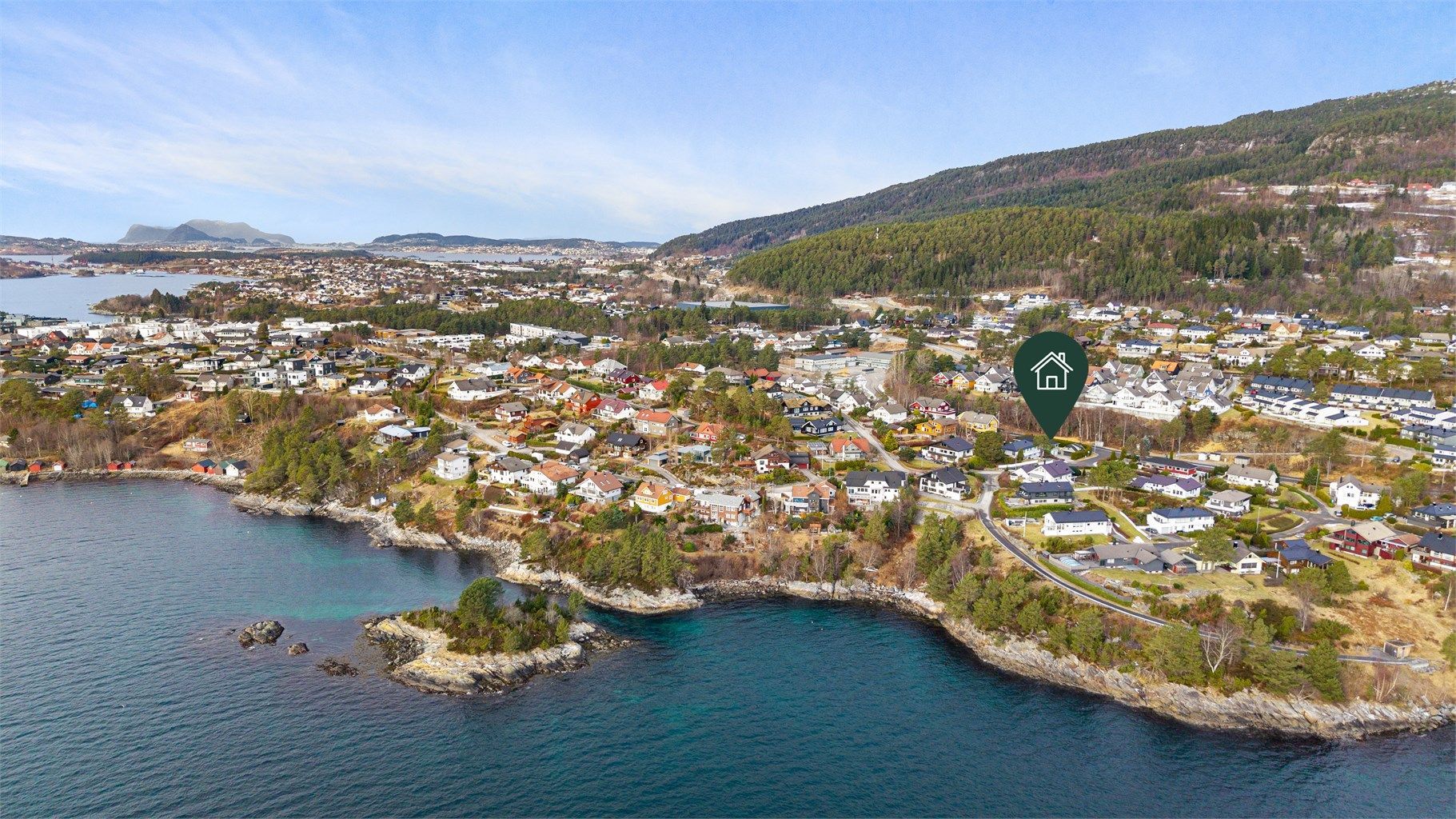 Dronebilde av boligområdet tatt fra sjøsiden med eiendommens plassering markert