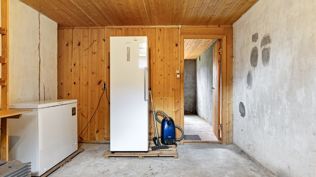 Alle gulvflater er i betong og veggene er i malte flater, panel og betong
