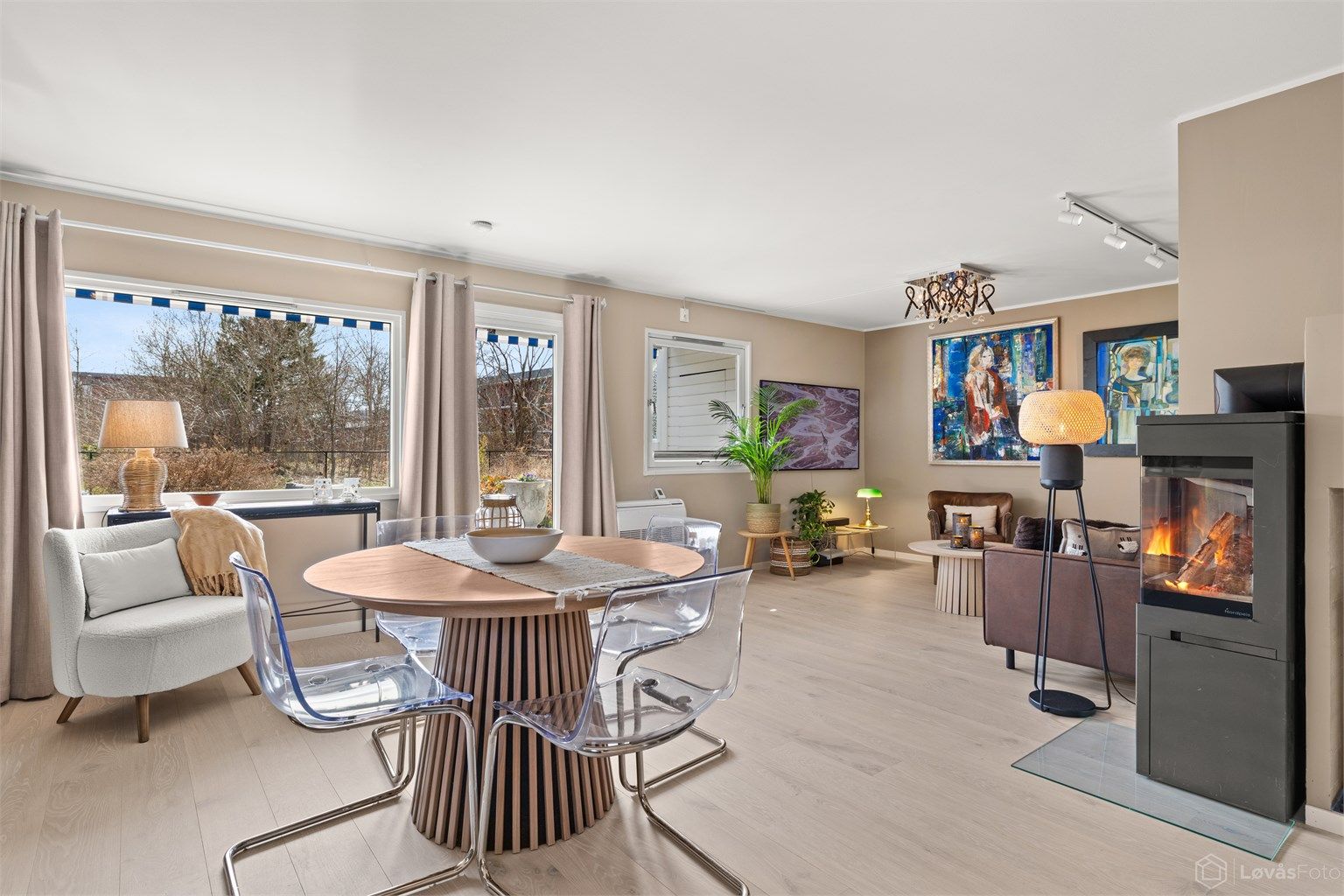 Den åpne løsningen mellom stue og kjøkken skaper en sosial og luftig atmosfære, med god plass til spisebord.