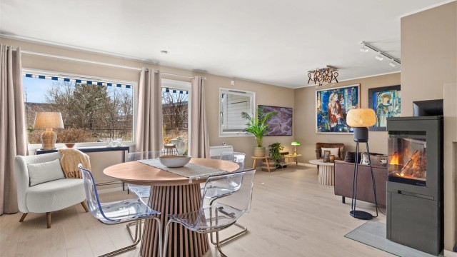 Den åpne løsningen mellom stue og kjøkken skaper en sosial og luftig atmosfære, med god plass til spisebord.