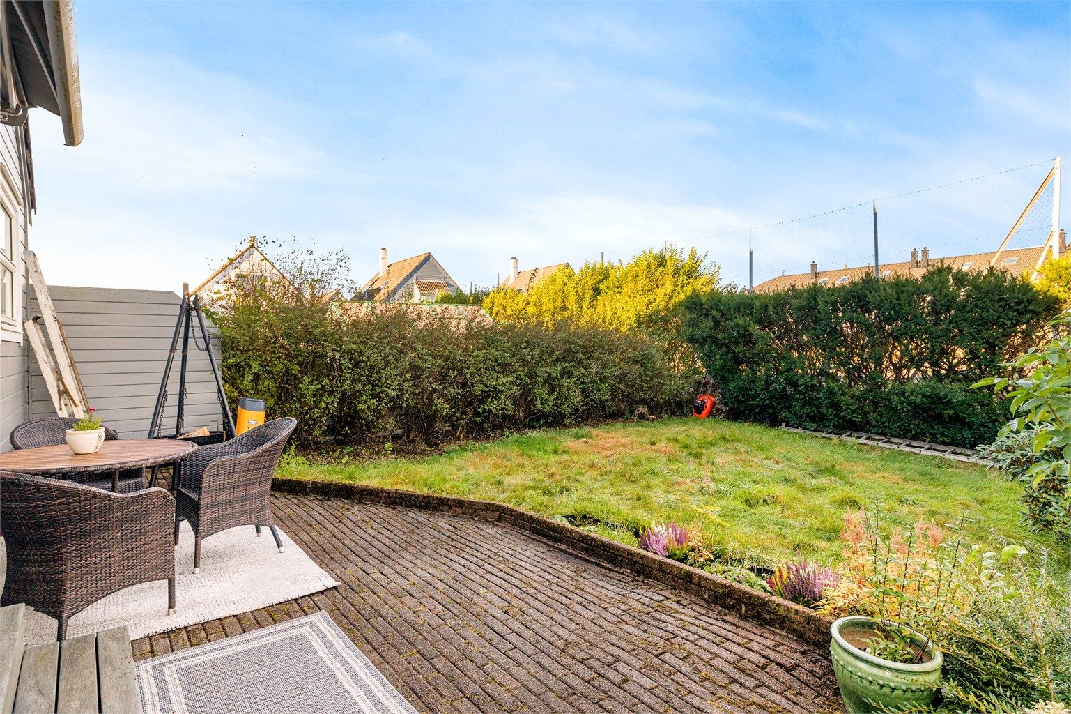 Skjermet markterrasse og hage med plass til utemøbler.