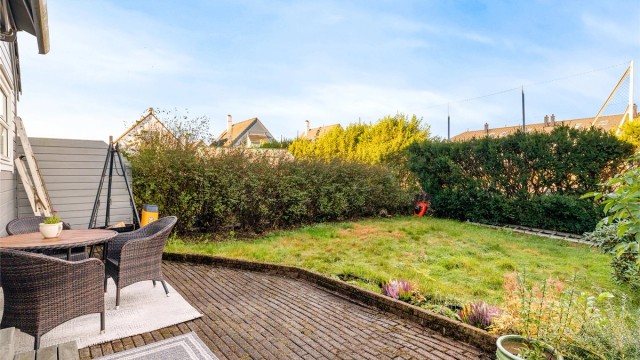Skjermet markterrasse og hage med plass til utemøbler.