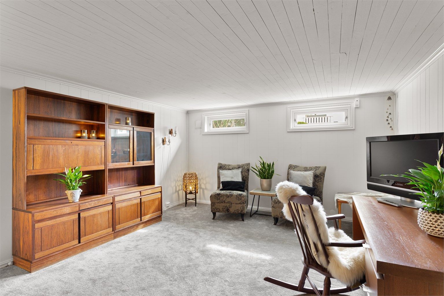 Innredet rom i kjelleren med vegg-til-vegg-teppe og panel på vegger. Rommet er ikke godkjent for varig opphold.