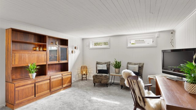 Innredet rom i kjelleren med vegg-til-vegg-teppe og panel på vegger. Rommet er ikke godkjent for varig opphold.