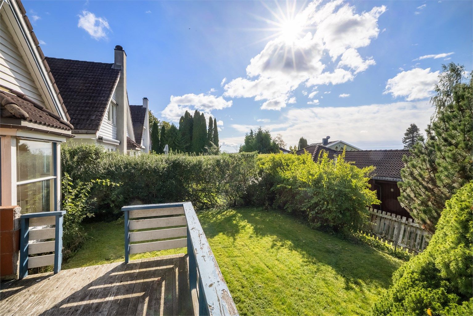 Boligen ligger på en tilbaketrukket og barnevennlig tomt, omkranset av plen og skjermende beplantning