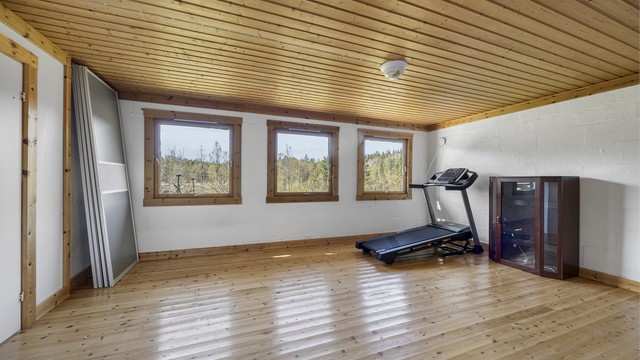 Rommet har tregulv og malte murvegger, med vinduer som gir godt med dagslys.