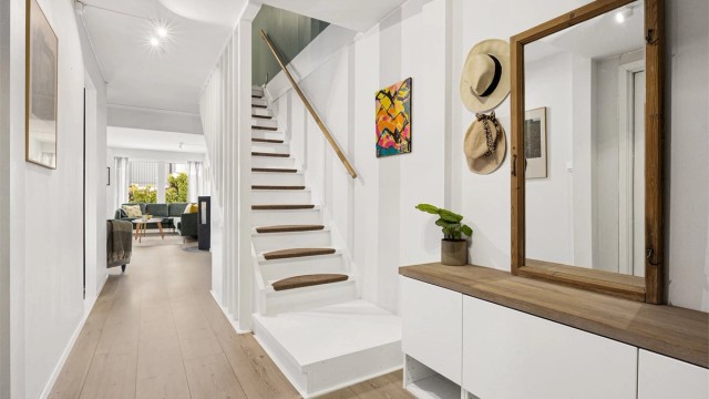 Fra entreen åpner boligen seg opp mot stuen, med trapp som leder til andre etasje.