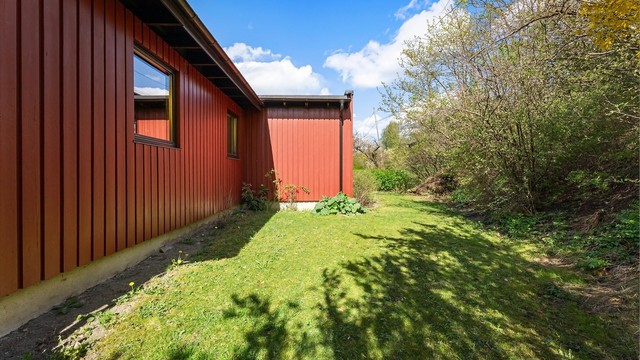 Hagen er pent opparbeidet med plenarealer og diverse beplantning.