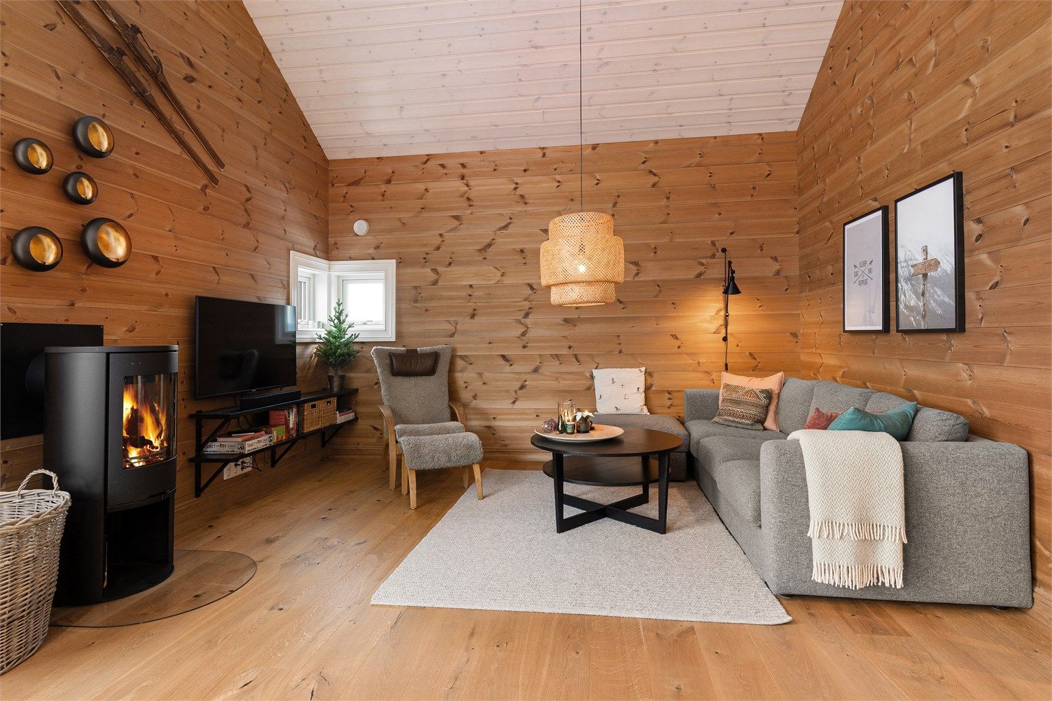 Koselig sofagruppe på stuen. Peisovn med glassdør som gir en lun og hyggelig atmosfære på kjølige dager