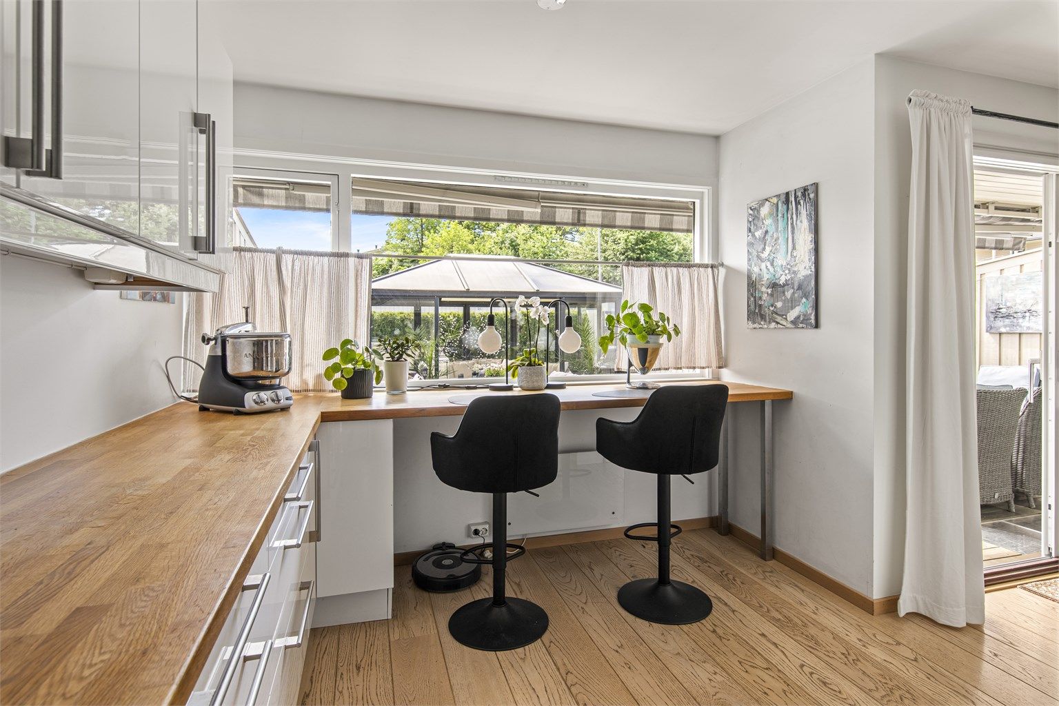 Kjøkkenet er innredet med hvite slette fronter og integrerte hvitevarer