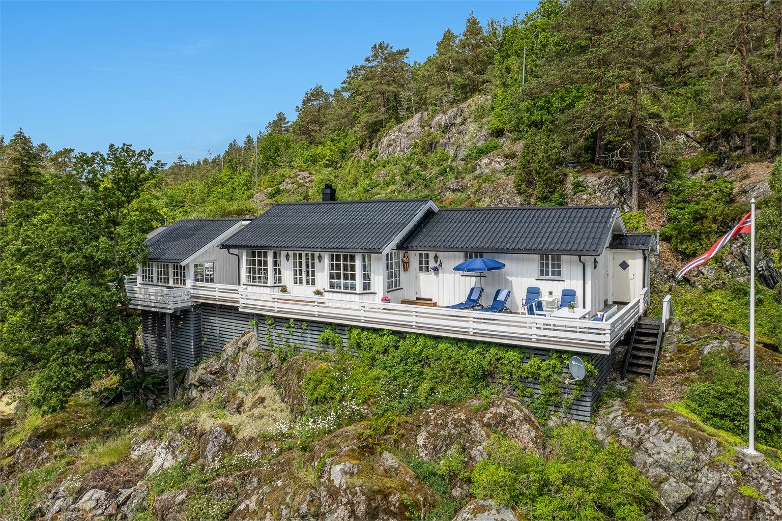 Terrassen strekker seg rundt hele hytta og gir rikelig med plass til spiseplasser, solstoler og loungegrupper.