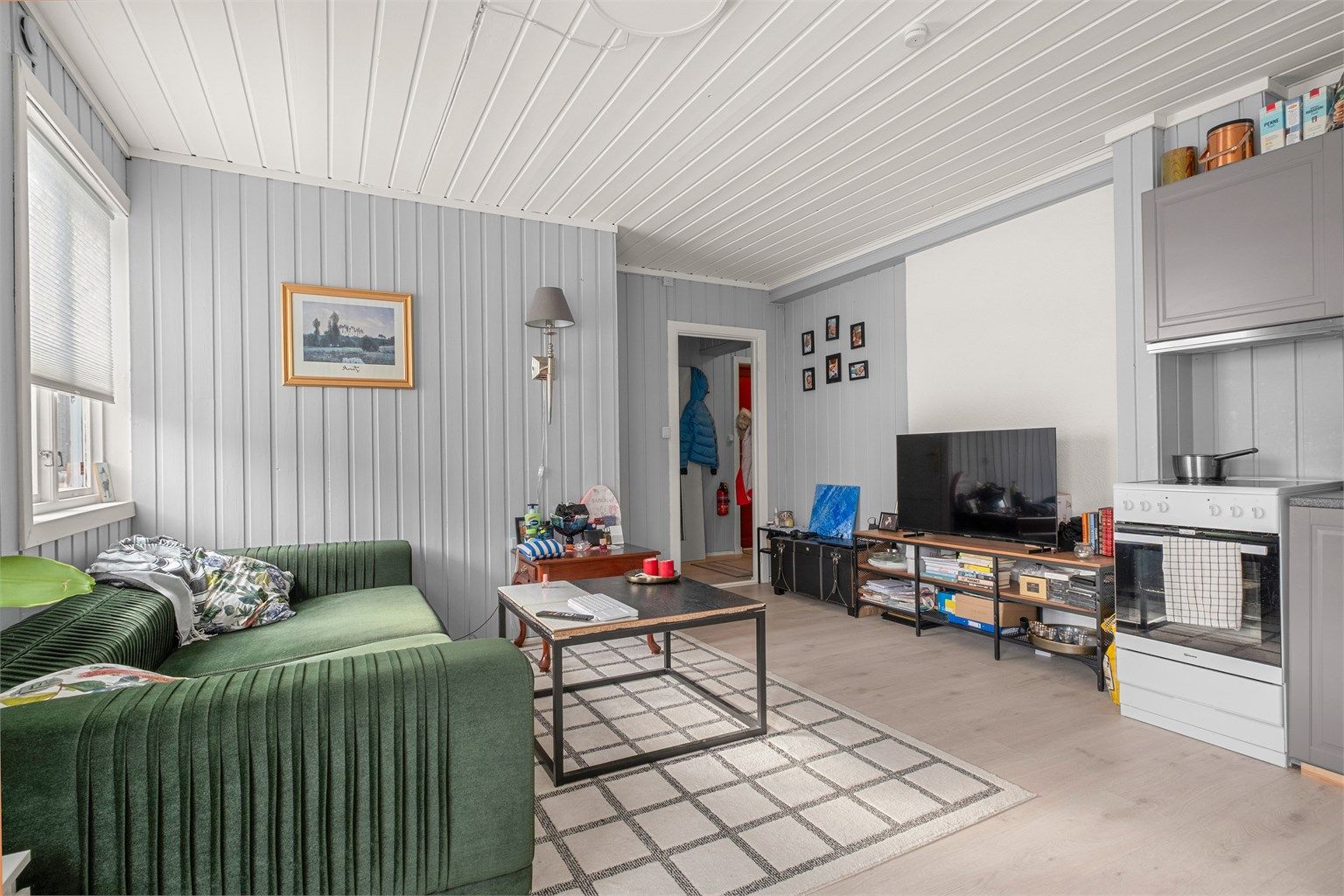 Her får du en hyggelig oppholdssone med åpen løsning mot kjøkkenet og plass til både sofa og TV-møblement.