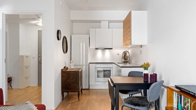 Kjøkkeninnredningen har hvite, glatte fronter og en slitesterk laminatbenkeplate.