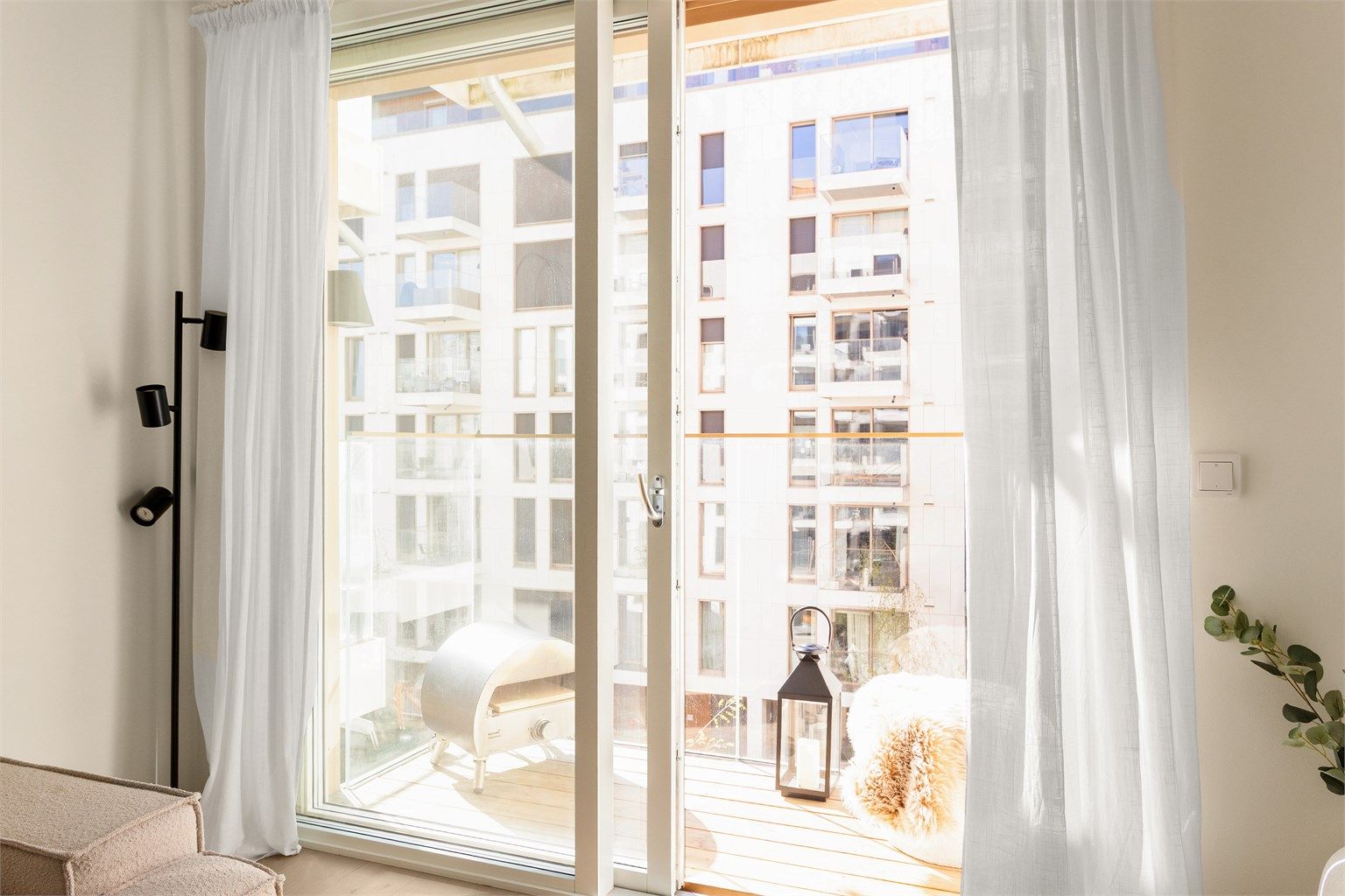 Store vindusflater og skyvedør til balkongen gir rikelig med naturlig lys og en god forbindelse til uterommet.