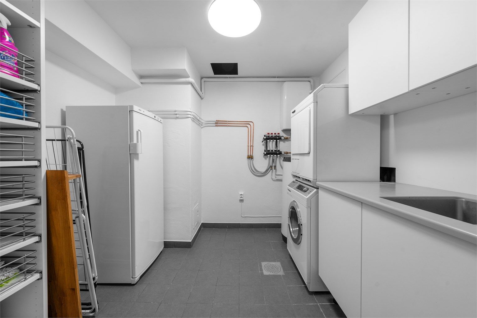 Praktisk vaskerom med god plass til både klesvask og oppbevaring. Varmtvannsberederen på 190L er plassert her.