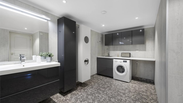 Badet fungerer også som vaskerom med opplegg for vaskemaskin, praktisk benkeplass og overskap.