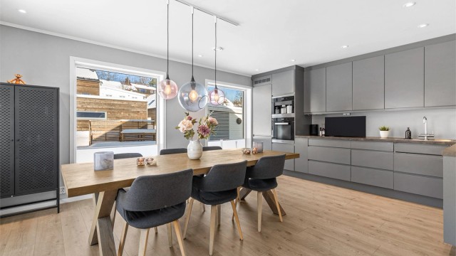 Åpen kjøkkenløsning. Innredning fra byggeår. Glatte fronter. Benkeplate med laminert overflate. Nedfelt kjøkkenvask med armatur.