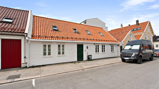 Klassisk og sjarmerende trehusfasade med tradisjonsrikt preg i et hyggelig gateløp.