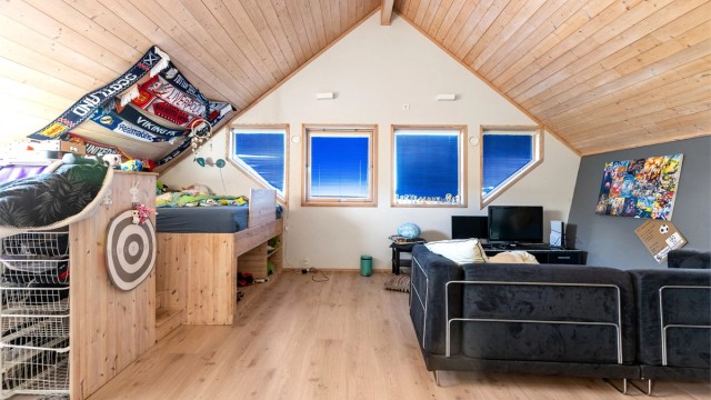 Det andre soverommet i etasjen er romslig og lyst, med plass til både seng og sittegruppe.