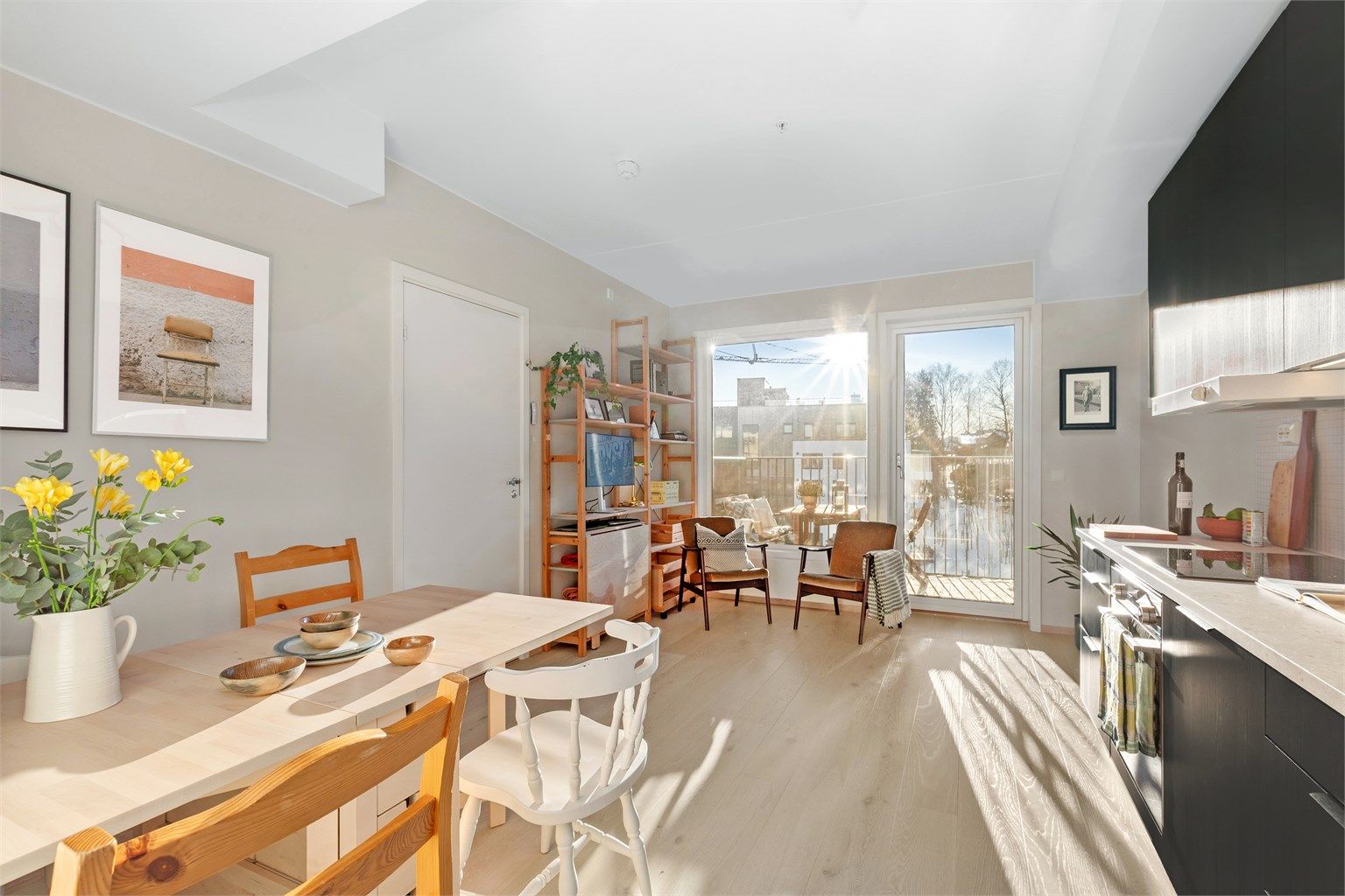 Lys stue med åpen kjøkkenløsning og store vindusflater