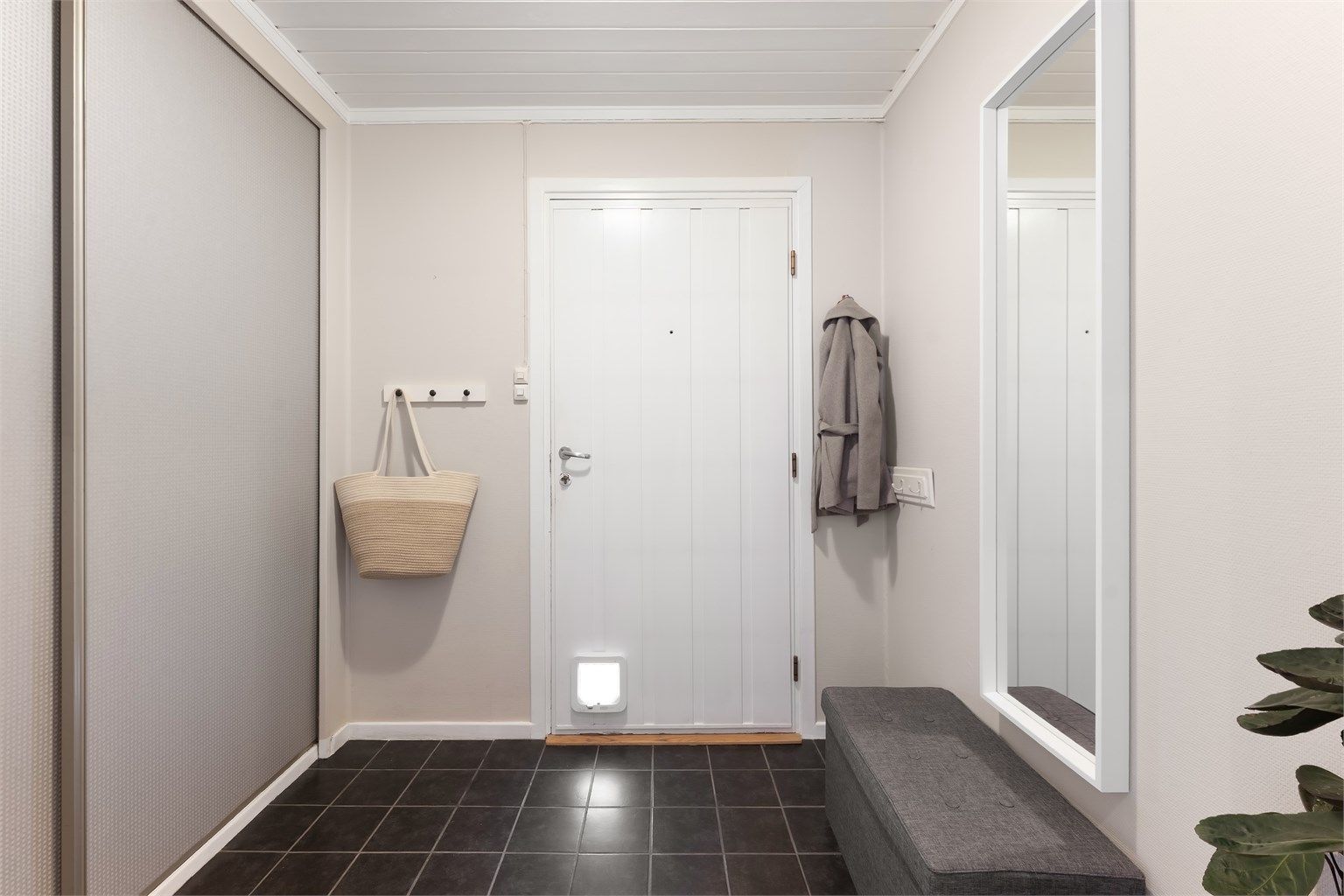 Vindfanget er praktisk innredet med flislagt gulv og plass til oppbevaring av yttertøy.