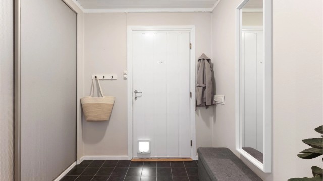 Vindfanget er praktisk innredet med flislagt gulv og plass til oppbevaring av yttertøy.