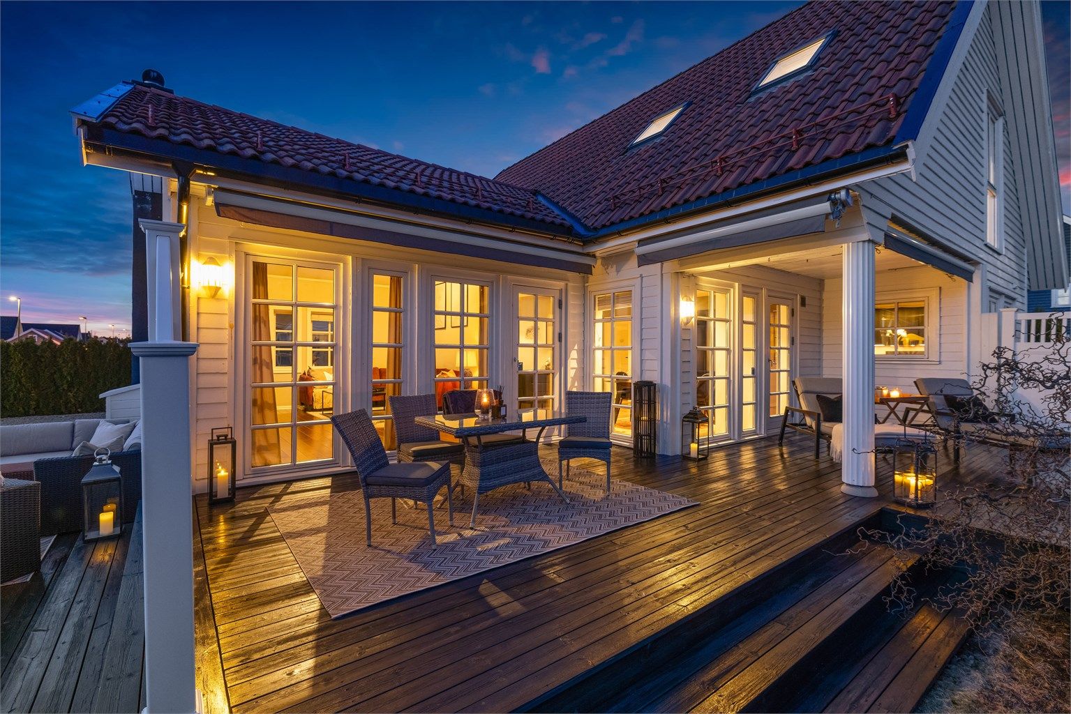 Belysning på fasaden og terrassen skaper en lun atmosfære.