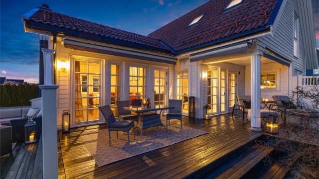 Belysning på fasaden og terrassen skaper en lun atmosfære.