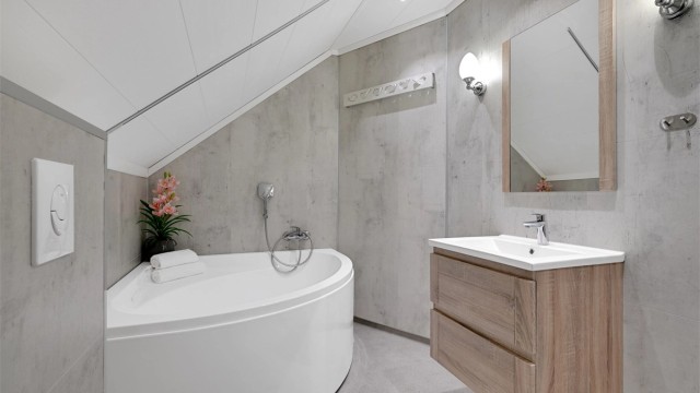 Badet på loftet ble ferdigstilt i 2018 og er utstyrt med et innbydende badekar.