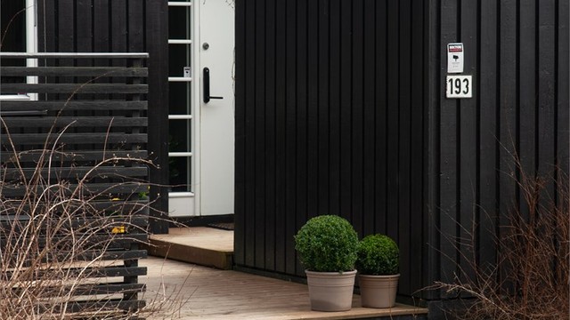 Adkomst til boligen via en treplatting. Entrédøren har elektrisk kodelås.