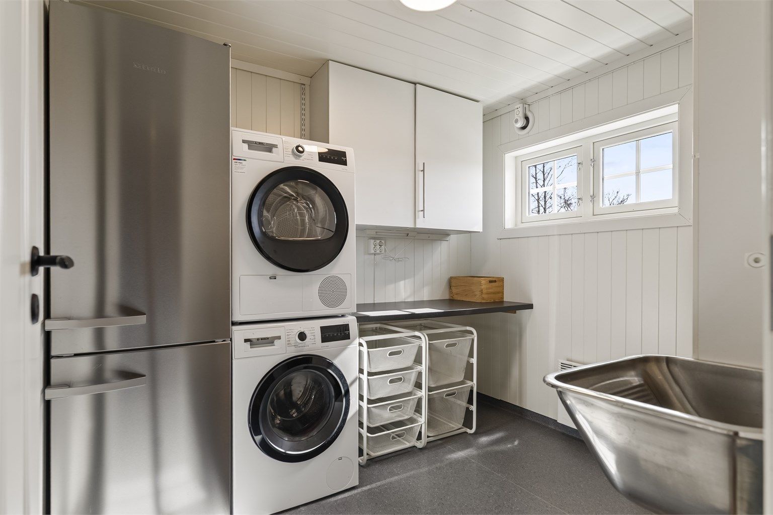 Separat vaskerom med opplegg for vaskemaskin og vegghengt utslagsvask.