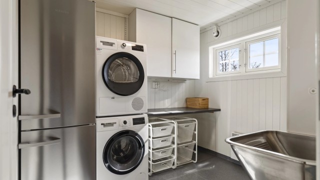 Separat vaskerom med opplegg for vaskemaskin og vegghengt utslagsvask.