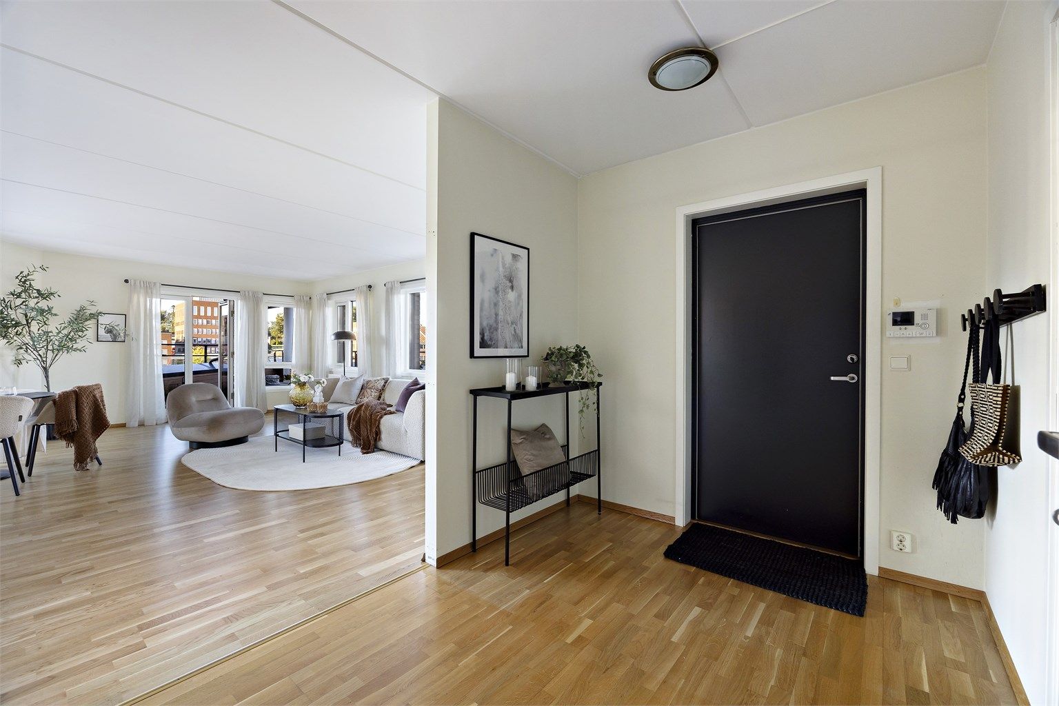 Velkommen inn i en lys entré med plass til konsollbord, knaggrekker og speil