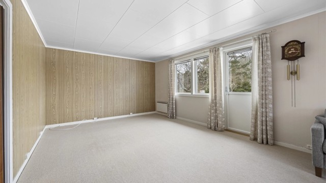 Oppholdsrommet har plass til flere sittegrupper og er et sentralt samlingspunkt i boligen.