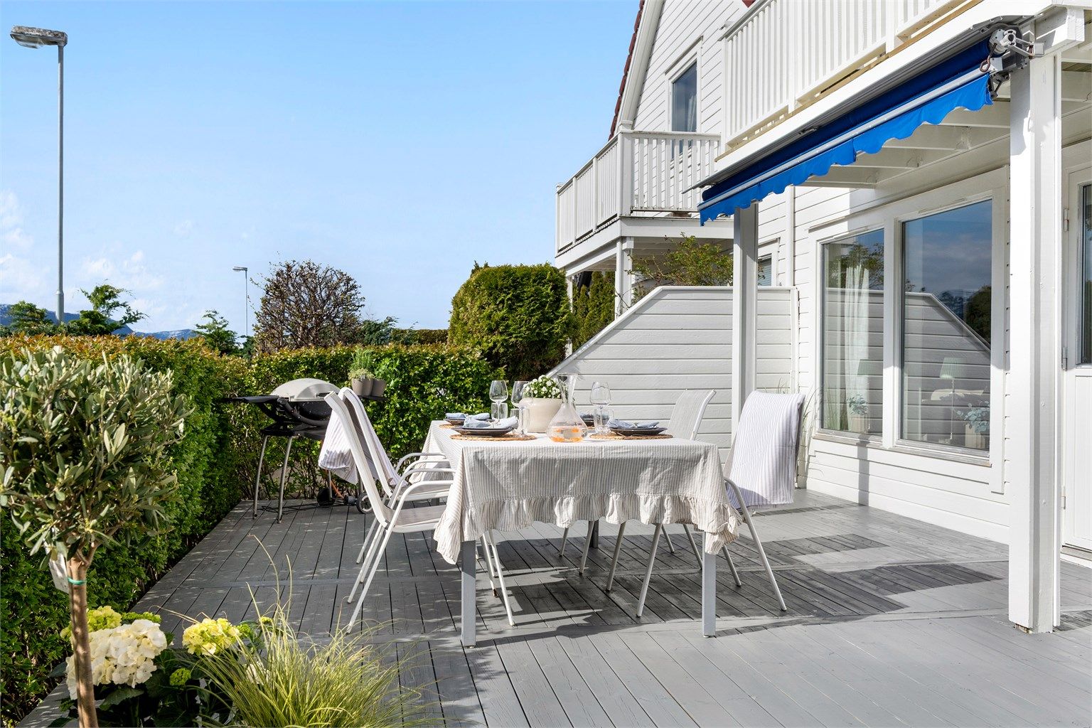 Her er det god plass til både spisebord og grill, skjermet av hekk og levegg mot nabo