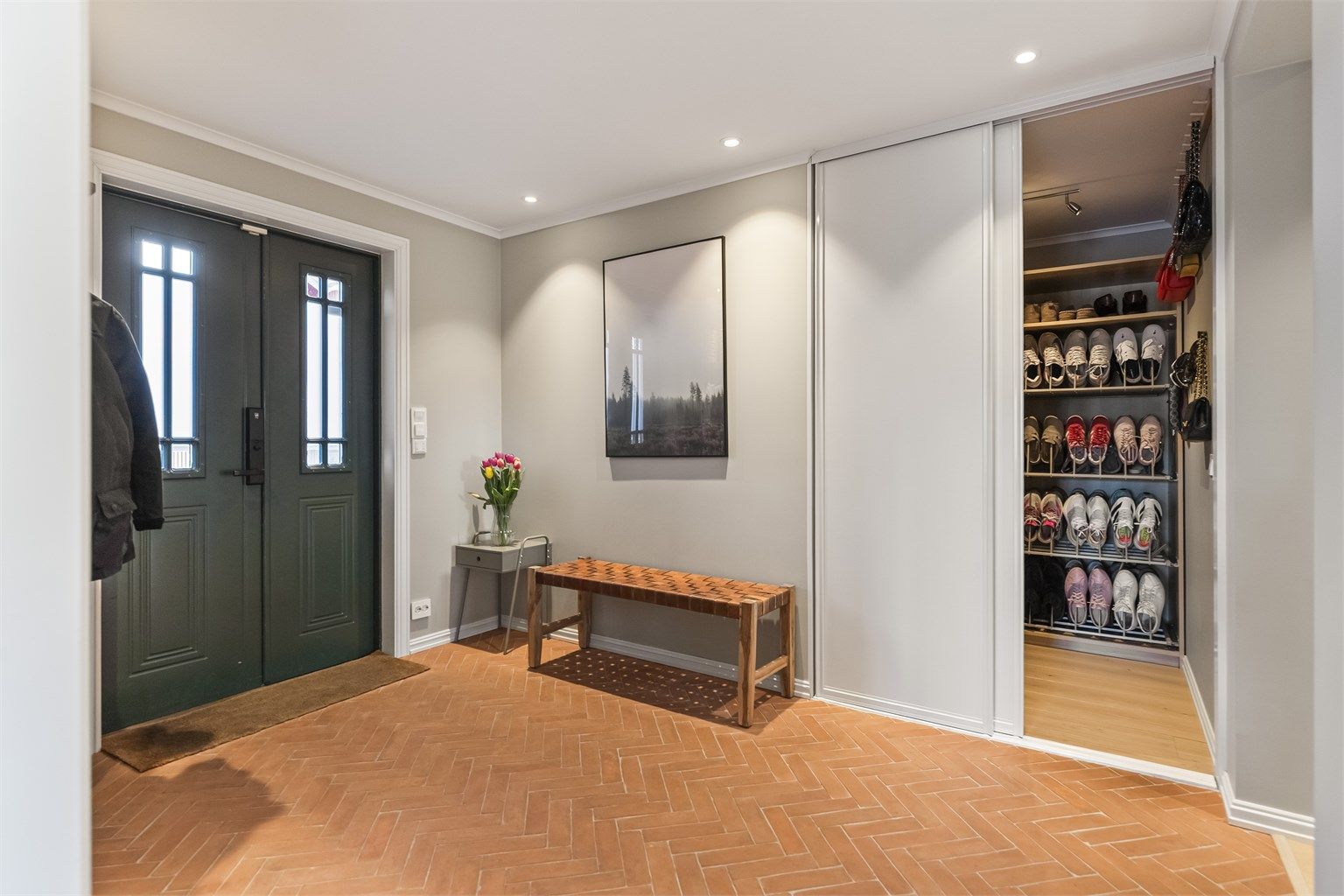 En stor skyvedørsgarderobe i entreen gir rikelig med plass til oppbevaring av yttertøy og sko.