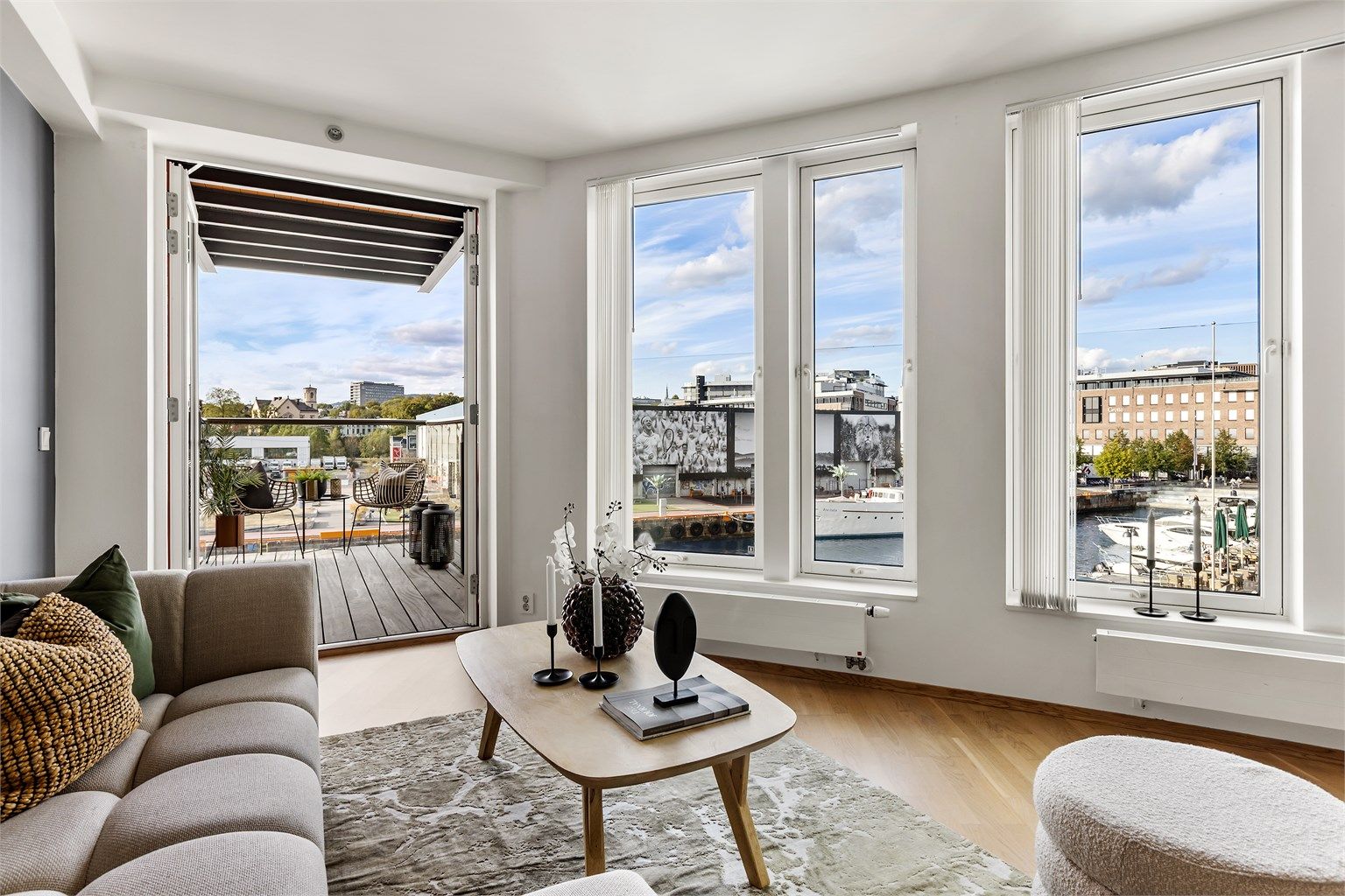 Stue/spisestue med åpen kjøkkenløsning, store vindusflater og utgang til overbygget nordvestvendt balkong.