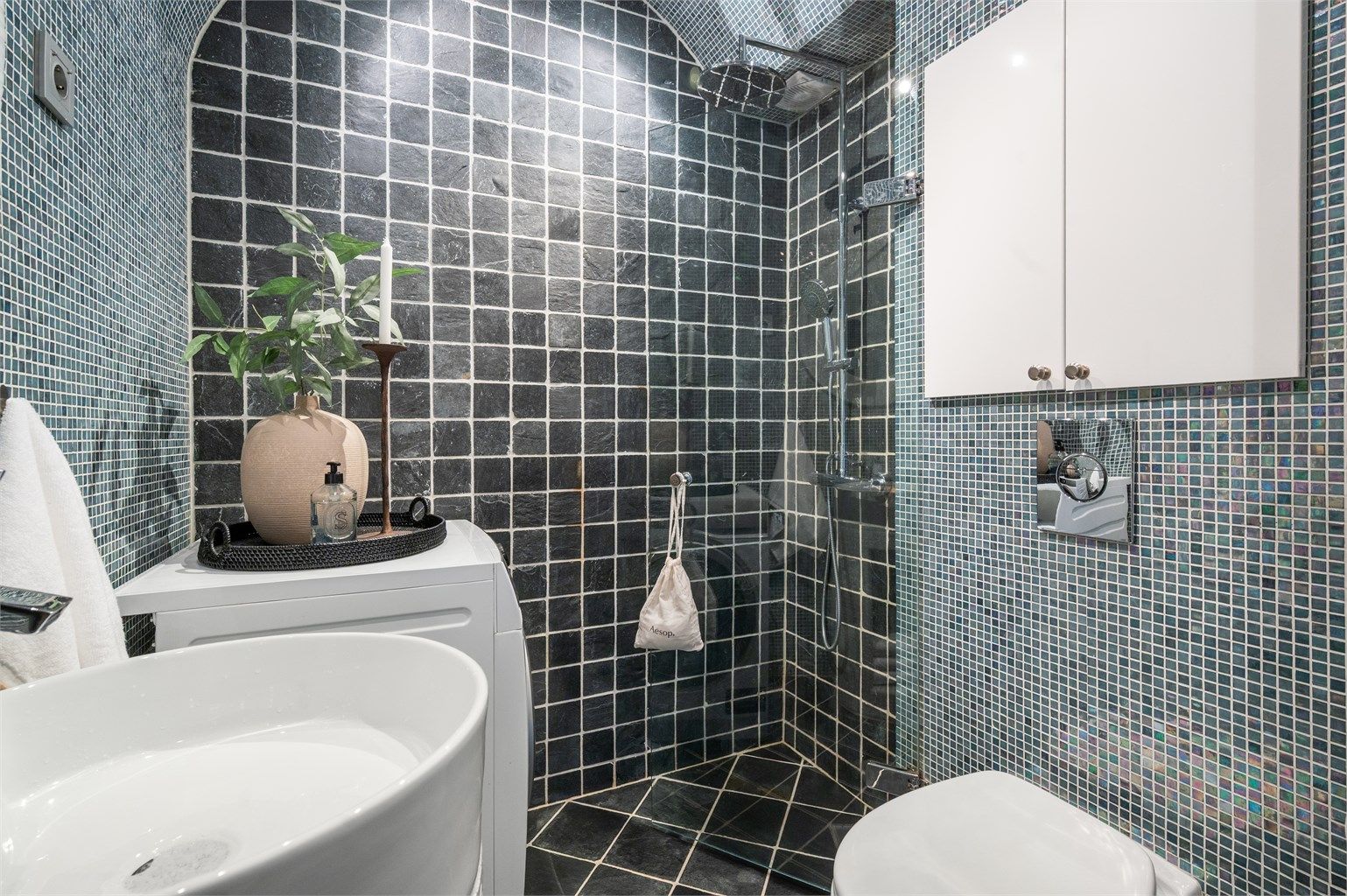 Mosaikkfliser på vegger og et buet tak gir badet et særpreget uttrykk.