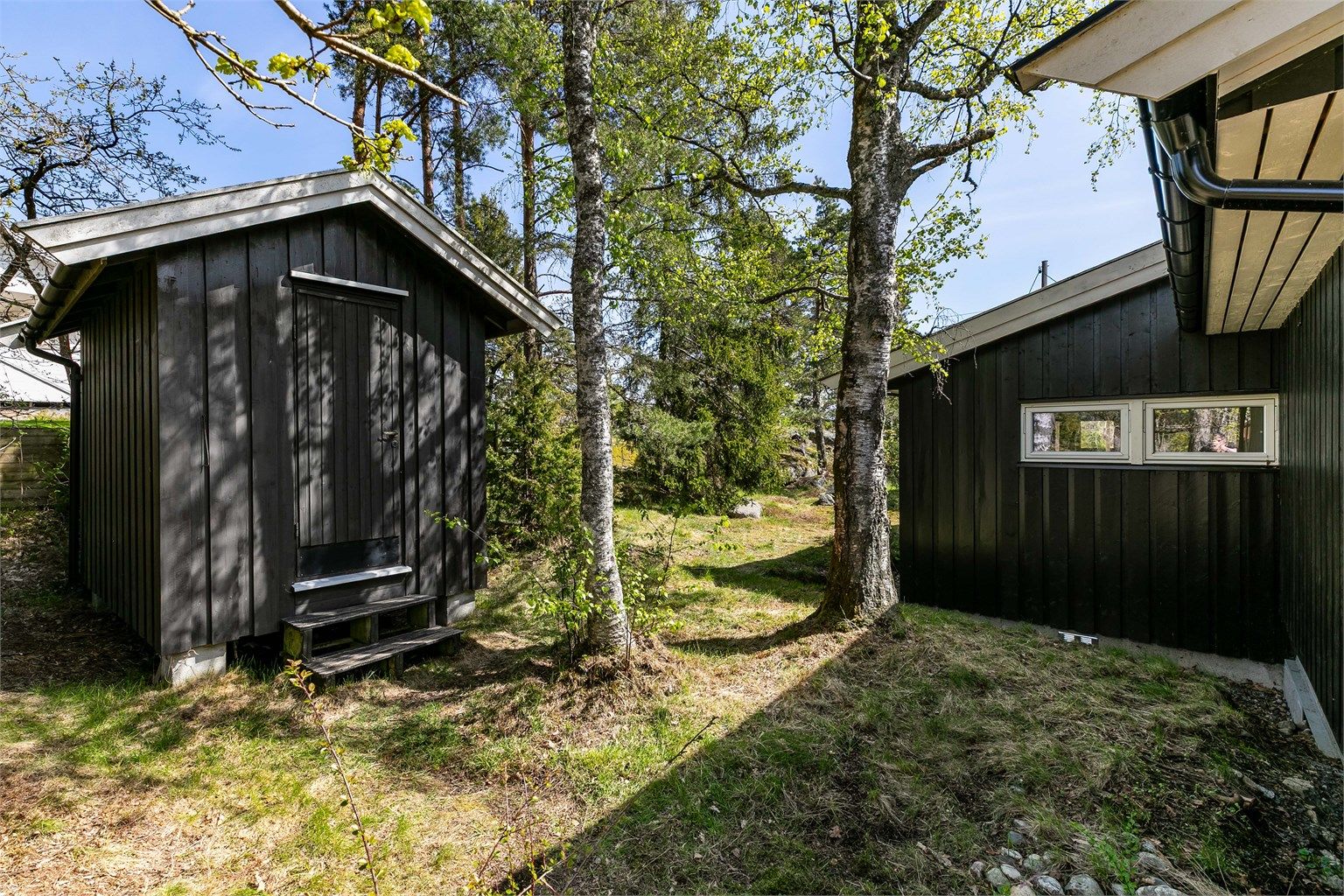 På baksiden av tilbygget står en praktisk hage-/redskapsbod.